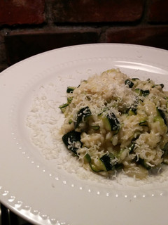 A picture of Risotto with thick slices of zucchini.