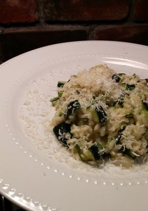 A picture of Risotto with thick slices of zucchini.