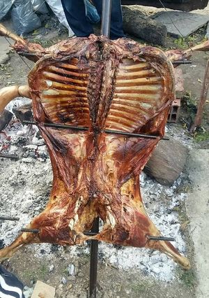 Una foto de Cordero asado y lechón a la estaca