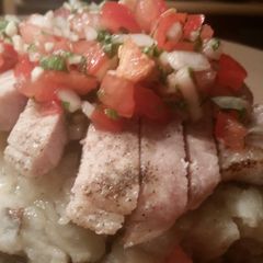 A picture of Tomato Basil Insalata over Sliced Broiled Pork Loin and Mashed Potatoes..