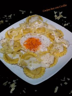 Una foto de Ravioles de queso con salsa de queso cheddar y huevo frito
