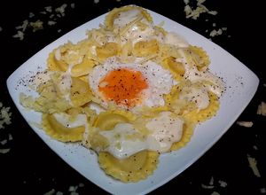 Foto principal de Ravioles de queso con salsa de queso cheddar y huevo frito