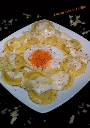 Una foto de Ravioles de queso con salsa de queso cheddar y huevo frito