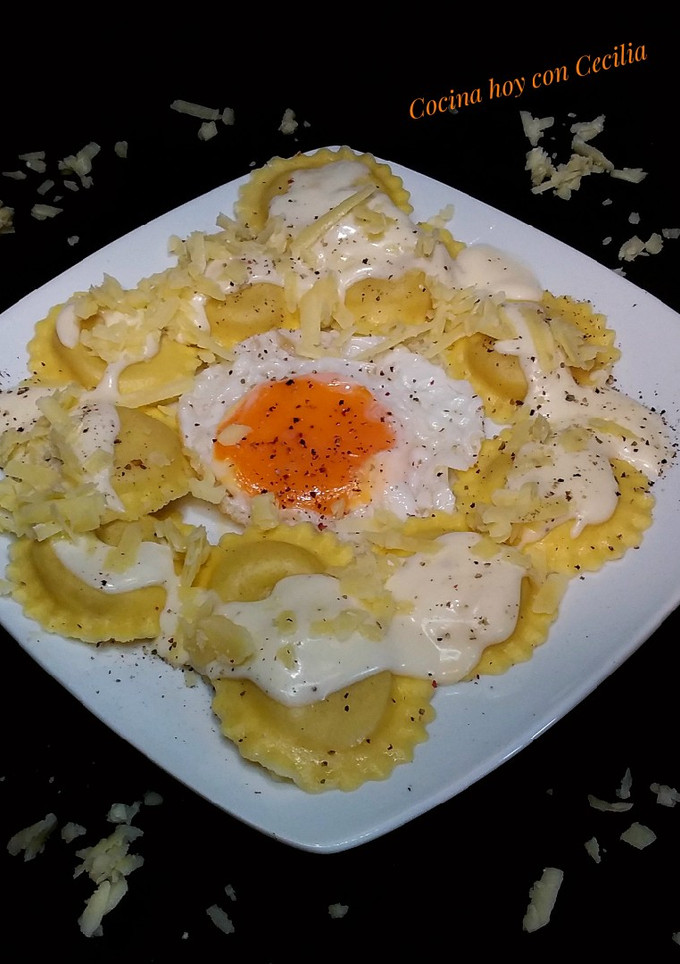 Una foto de Ravioles de queso con salsa de queso cheddar y huevo frito