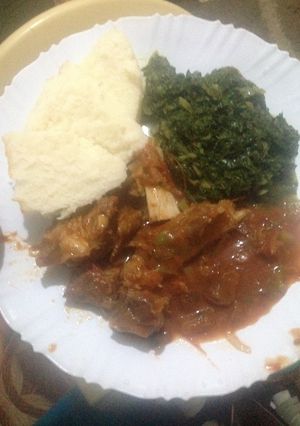 A picture of Ugali served with fried beef and spinach.