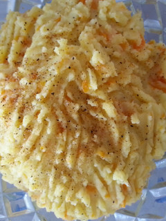 A picture of Mash potatoes carrots with bacon.