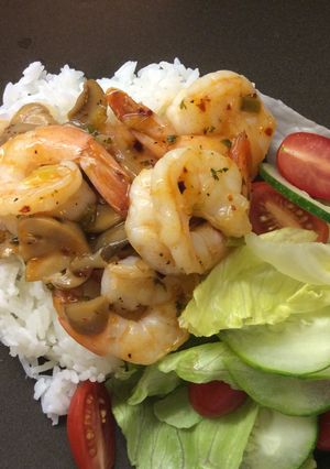A picture of Shrimp with mushroom in butter sauce.