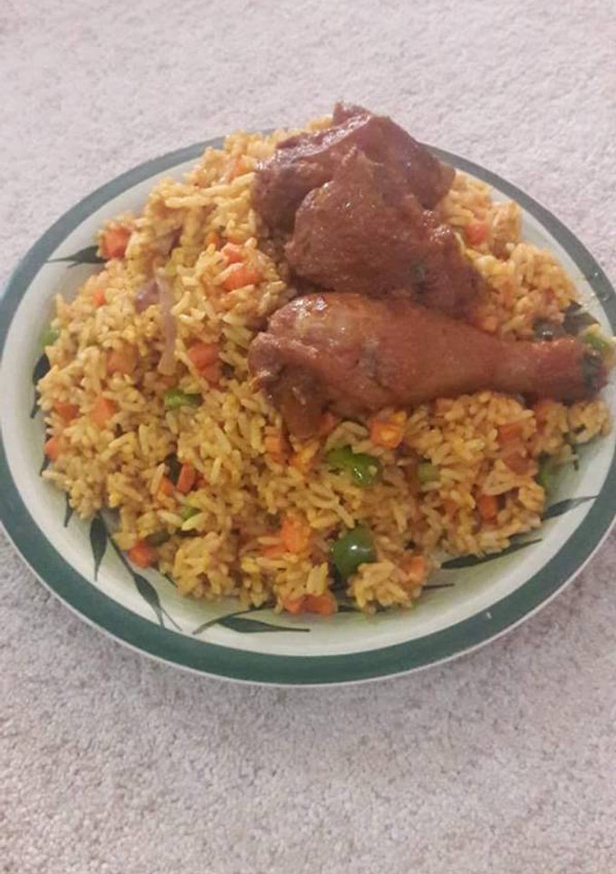 A picture of Jollpf rice with veggies and fried chicken.