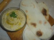 A picture of hummus with pita bread