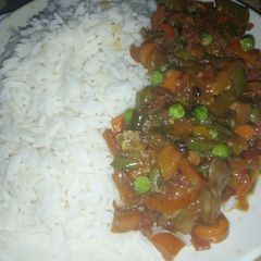 A picture of White rice with veggies sauce.