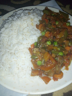 A picture of White rice with veggies sauce.