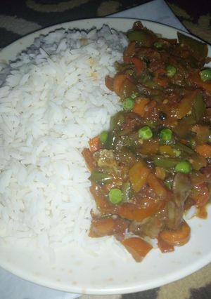 A picture of White rice with veggies sauce.
