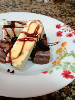 Una foto de Fudge de chocolate blanco y negro con pistachos, arándanos