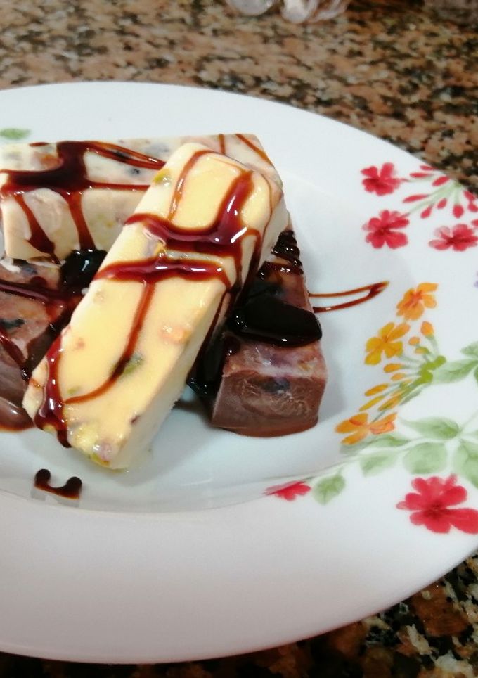 Una foto de Fudge de chocolate blanco y negro con pistachos, arándanos