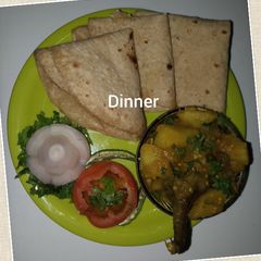 A picture of Potato brinjal bhaji chapati and onion tomato salad.