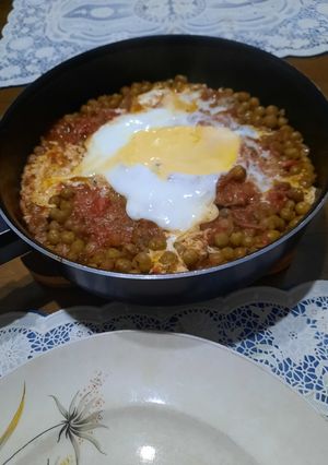 Una foto de Bifecitos en sartén con arvejas huevo y salsa