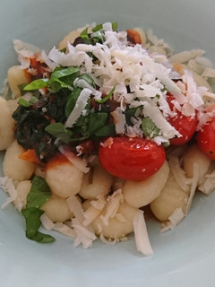 Una foto de Gnocchi con espinacas y tomates cherry