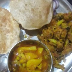 A picture of Aloo matar Tamatar and gobhi ki sabji with Puri.