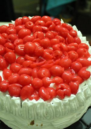 A picture of Layered upside down apple caramel cinnamon cake with whipped cream and cherries.