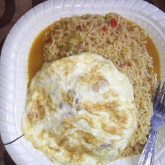 A picture of Indomie jollof and fried egg.