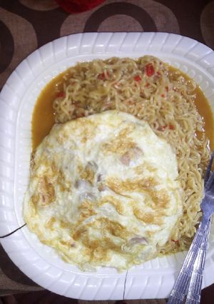 A picture of Indomie jollof and fried egg.