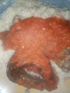 A picture of Rice and beans with panla fish and sauce.