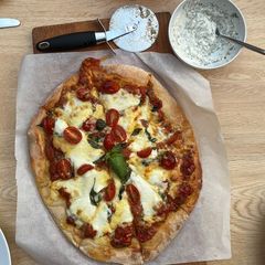 A picture of Caprese pizza with garlic and herb dip.