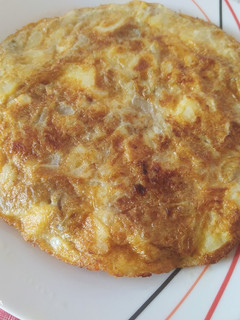 Una foto de Tortilla de patatas, cebolla y berenjena y acompañada de dos pinchos