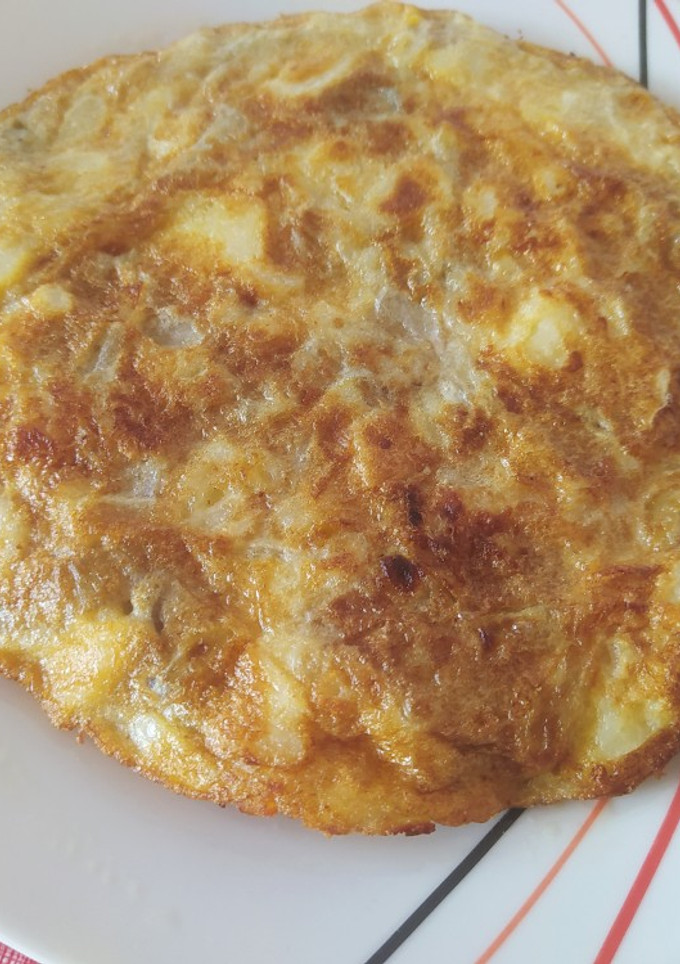 Una foto de Tortilla de patatas, cebolla y berenjena y acompañada de dos pinchos