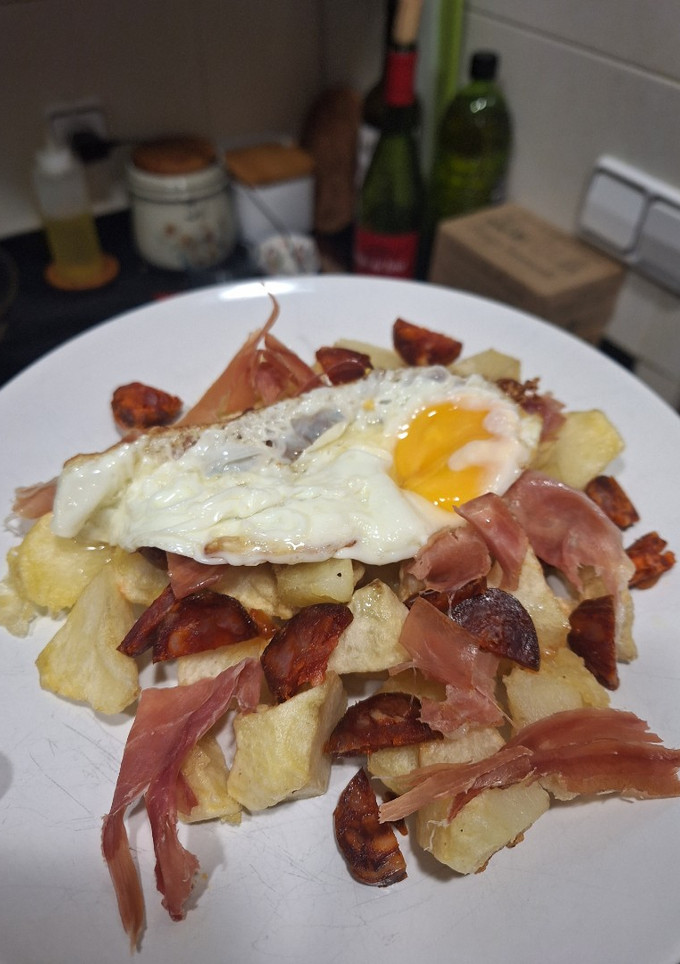 Una foto de Patatas con chorizo, jamón y huevo