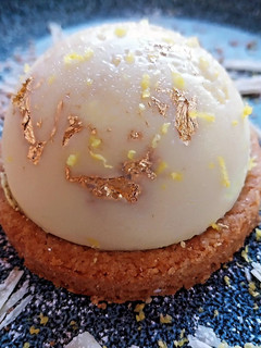 Una foto de Mousse de limón con polvo de oro y cobertura de chocolate blanco