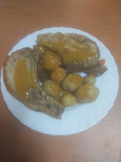 Una foto de Chuletas de cerdo adobadas con papas arrugás y salsa
