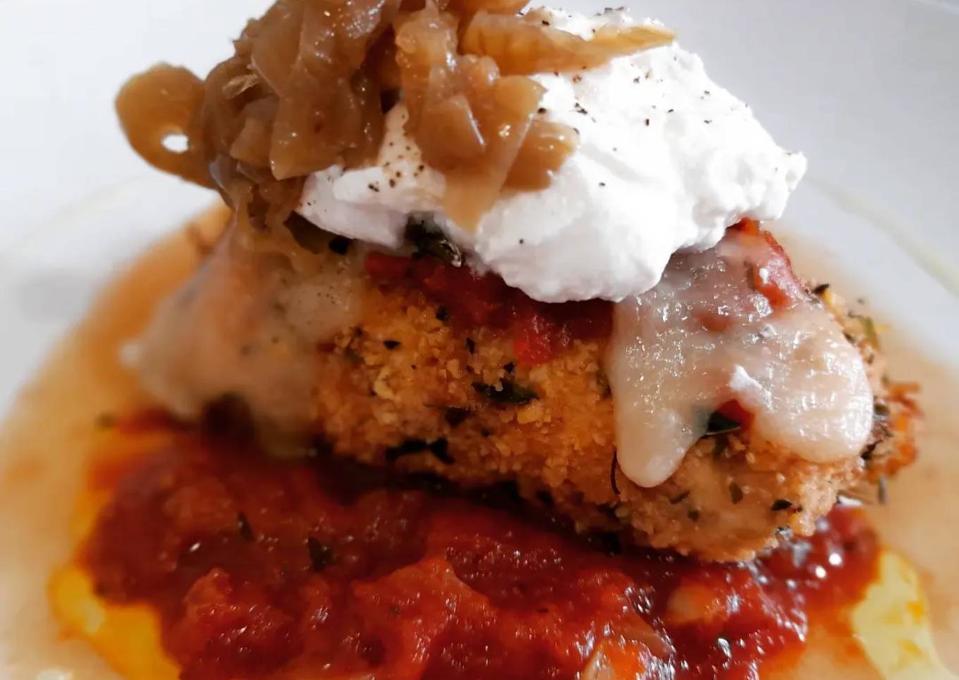 Pollo a la parmesana con ricotta y cebolla caramelizada