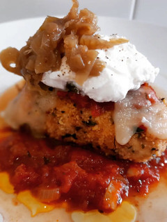 Una foto de Pollo a la parmesana con ricotta y cebolla caramelizada