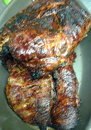 A picture of Pork brisket on the grill with semi- dry rub.