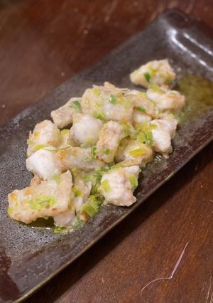 A picture of Monkfish meunière with leek green and lemon juice.