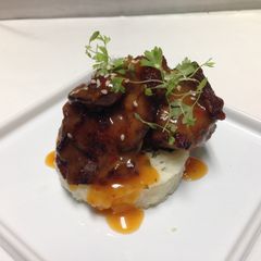 A picture of crispy pig cheeks with spicy pineapple,orange glaze and thai basil,lemon rice.