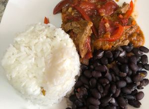 Una foto de Vacuno con rajas rojas adobadas acompañando de arroz blanco con frijoles