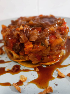 Una foto de Timbal de patatas y pisto con butifarra negra y blanca
