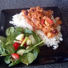 A picture of chicken tikka masala with salad.