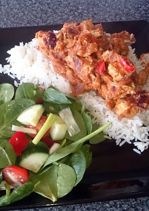 A picture of chicken tikka masala with salad.