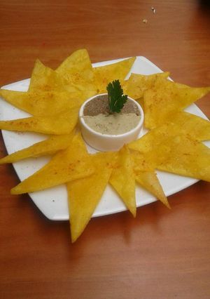 Una foto de Totopos con hummus de lenteja y tahini