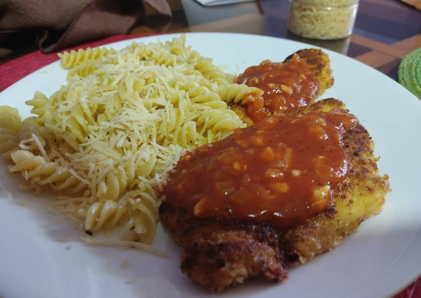 Pechuga empanizada bañada en salsa de tomate