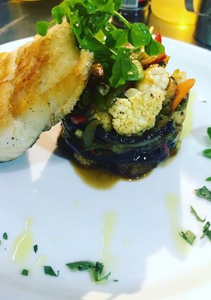 Una foto de Merluza a la plancha con timbal de verduras salteadas