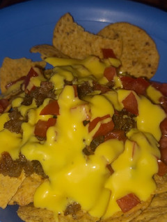 Una foto de Nachos con chicharrón bañados con queso amarillo (De la Ramos)