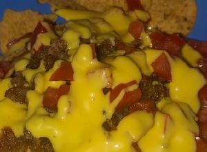 Una foto de Nachos con chicharrón bañados con queso amarillo (De la Ramos)