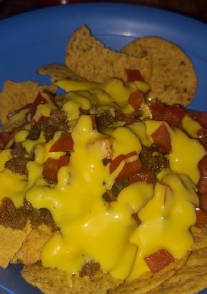 Una foto de Nachos con chicharrón bañados con queso amarillo (De la Ramos)