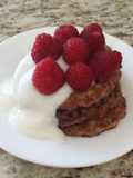 Vegan apple wheat pancake topped with yogurt and berries