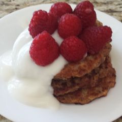 A picture of Vegan apple wheat pancake topped with yogurt and berries.