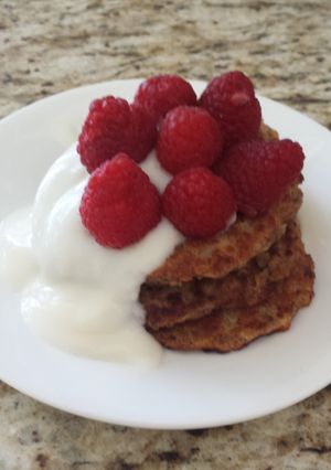 A picture of Vegan apple wheat pancake topped with yogurt and berries.